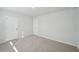 Bright bedroom with neutral walls and carpet, featuring two doors at 11834 Rizvan Pl, Covington, GA 30014