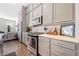 Modern kitchen featuring gray cabinets, white backsplash and stainless steel appliances at 10120 Windalier Way, Roswell, GA 30076