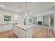 Spacious kitchen with white cabinets, granite island, and LVP flooring at 11814 Rizvan Pl, Covington, GA 30014