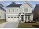 Two-story gray house with two-car garage and landscaping at 11814 Rizvan Pl, Covington, GA 30014