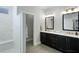 Bathroom with double vanity, marble shower, and dark cabinets at 3467 Fishpond Cir, Dacula, GA 30019