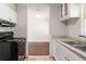 View of kitchen with white cabinets, stove, and access to dining area at 182 Arcadia Nw Cir, Atlanta, GA 30314