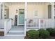 Charming front porch with white railing, a light teal door, and welcoming decor at 14020 Tributary Ln, Villa Rica, GA 30180