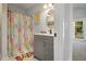 Bright bathroom with gray vanity, shower, and beach-themed decor at 14020 Tributary Ln, Villa Rica, GA 30180