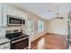 Open concept kitchen and living area with stainless steel appliances and hardwood floors at 9170 Jefferson Sw Ave, Covington, GA 30014
