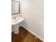 Small powder room with pedestal sink and hardwood floors at 4060 Willowmere Pointe Nw, Kennesaw, GA 30144