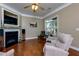 Bright living room featuring hardwood floors, a fireplace and large windows at 1220 Heartwood Ave, Mcdonough, GA 30253