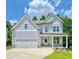 Two-story house with gray siding, stone accents, and a three-car garage at 4444 Sullivan Road, Powder Springs, GA 30127