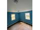 Bedroom with two windows, light wood floors, and blue walls at 8165 Thompson St, Douglasville, GA 30134