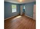 Bedroom with wood-look floors, blue walls, and access to bathroom at 8165 Thompson St, Douglasville, GA 30134