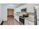 Modern kitchen with white cabinets, granite countertops and stainless steel appliances at 443 Creekwood Pass, Dallas, GA 30157