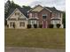 Two-story house with brick and siding, red accents, and a manicured lawn at 300 Redford Trl, Stockbridge, GA 30281