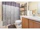 Bathroom with shower/tub combo, wood vanity, and gray damask shower curtain at 2608 Downing Park Se Dr, Conyers, GA 30094