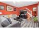 Living room boasts a sectional sofa, a large TV, and an orange accent wall at 2608 Downing Park Se Dr, Conyers, GA 30094