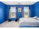 Blue bedroom with two windows, carpet, and a bed at 2608 Downing Park Se Dr, Conyers, GA 30094