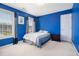 Bright bedroom with blue walls, double windows, and carpeted floor at 2608 Downing Park Se Dr, Conyers, GA 30094