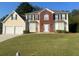 Two-story brick and siding house with a two-car garage and manicured lawn at 2608 Downing Park Se Dr, Conyers, GA 30094