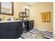 Bathroom with double vanity, dark cabinets, and patterned floors at 2608 Downing Park Se Dr, Conyers, GA 30094