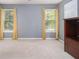 Simple bedroom with gray walls, neutral carpet, and two windows at 2608 Downing Park Se Dr, Conyers, GA 30094