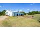 Large white barn with multiple stalls and a gated area at 787 Tidwell Rd, Powder Springs, GA 30127