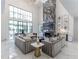 Spacious living room with gray sofas, marble floors, and a large fireplace at 3915 Muirfield Sq, Duluth, GA 30096