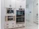 Modern kitchen with double ovens and built-in coffee maker at 3915 Muirfield Sq, Duluth, GA 30096