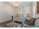 Bright bedroom with a four-poster bed, hardwood floors, and a chandelier at 3915 Muirfield Sq, Duluth, GA 30096