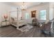 Elegant bedroom featuring a four-poster bed, hardwood floors, and a chandelier at 3915 Muirfield Sq, Duluth, GA 30096