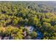 Aerial view of house and surrounding lush forest at 3915 Muirfield Sq, Duluth, GA 30096