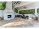 Covered patio with stone fireplace and seating area at 3915 Muirfield Sq, Duluth, GA 30096