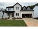 New construction home with white brick, black trim, and covered front porch at 5301 Woodline View Cir, Auburn, GA 30011