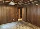 Unfinished basement room with wood paneling and damaged flooring at 5185 Erin Sw Rd, Atlanta, GA 30331