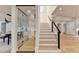 Modern staircase with glass wine cellar and hardwood floors at 5255 Buice Rd, Alpharetta, GA 30022
