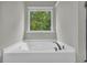 Corner bathtub with a window providing natural light at 239 Hardy Water Dr, Lawrenceville, GA 30045