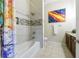 Modern bathroom with a tub/shower combo, tile accents, and an artistic painting at 1910 Cedar Glenn Way # 4403, Atlanta, GA 30339