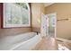 Relaxing bathroom featuring a jetted tub and large window with plantation shutters at 4930 Longridge Dr, Villa Rica, GA 30180