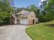 House exterior showcasing stone, a two car garage, and landscaping at 4930 Longridge Dr, Villa Rica, GA 30180
