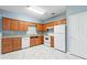 Kitchen boasts wood cabinets, white appliances, and laminate flooring at 1467 Riverrock Trl, Riverdale, GA 30296