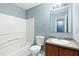 Clean bathroom with a tub, toilet, vanity with wood cabinets, and mirror at 1467 Riverrock Trl, Riverdale, GA 30296
