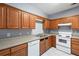 Kitchen features wood cabinets, white appliances, and laminate flooring at 1467 Riverrock Trl, Riverdale, GA 30296