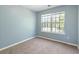 Bright bedroom with light blue walls, carpet flooring, and window at 1467 Riverrock Trl, Riverdale, GA 30296