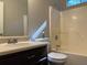 Clean bathroom featuring a shower/tub combo, toilet and vanity with dark brown cabinets at 5606 Rockingwood Ct, Atlanta, GA 30349