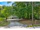 Two-story house with large front yard and driveway, surrounded by lush trees at 174 Rivertown Rd, Fairburn, GA 30213