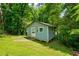 Small shed nestled in a wooded backyard at 174 Rivertown Rd, Fairburn, GA 30213