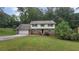 Two-story house with a brick and siding exterior, attached garage, and landscaping at 1081 Avonridge Ct, Stone Mountain, GA 30083