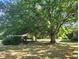 Large backyard with shade trees and a covered patio area at 684 N Cherokee N Rd, Social Circle, GA 30025