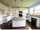 Modern kitchen with granite island, white cabinets, and dark hardwood floors at 2469 Osceola Rd, Lithonia, GA 30058