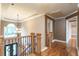 Elegant hardwood floors in upstairs hallway with a chandelier at 2505 Westchester Way, Conyers, GA 30013