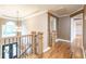 Elegant hardwood floors in upstairs hallway with a chandelier at 2505 Westchester Way, Conyers, GA 30013