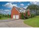 Side view of two-story brick home with attached two-car garage at 2505 Westchester Way, Conyers, GA 30013